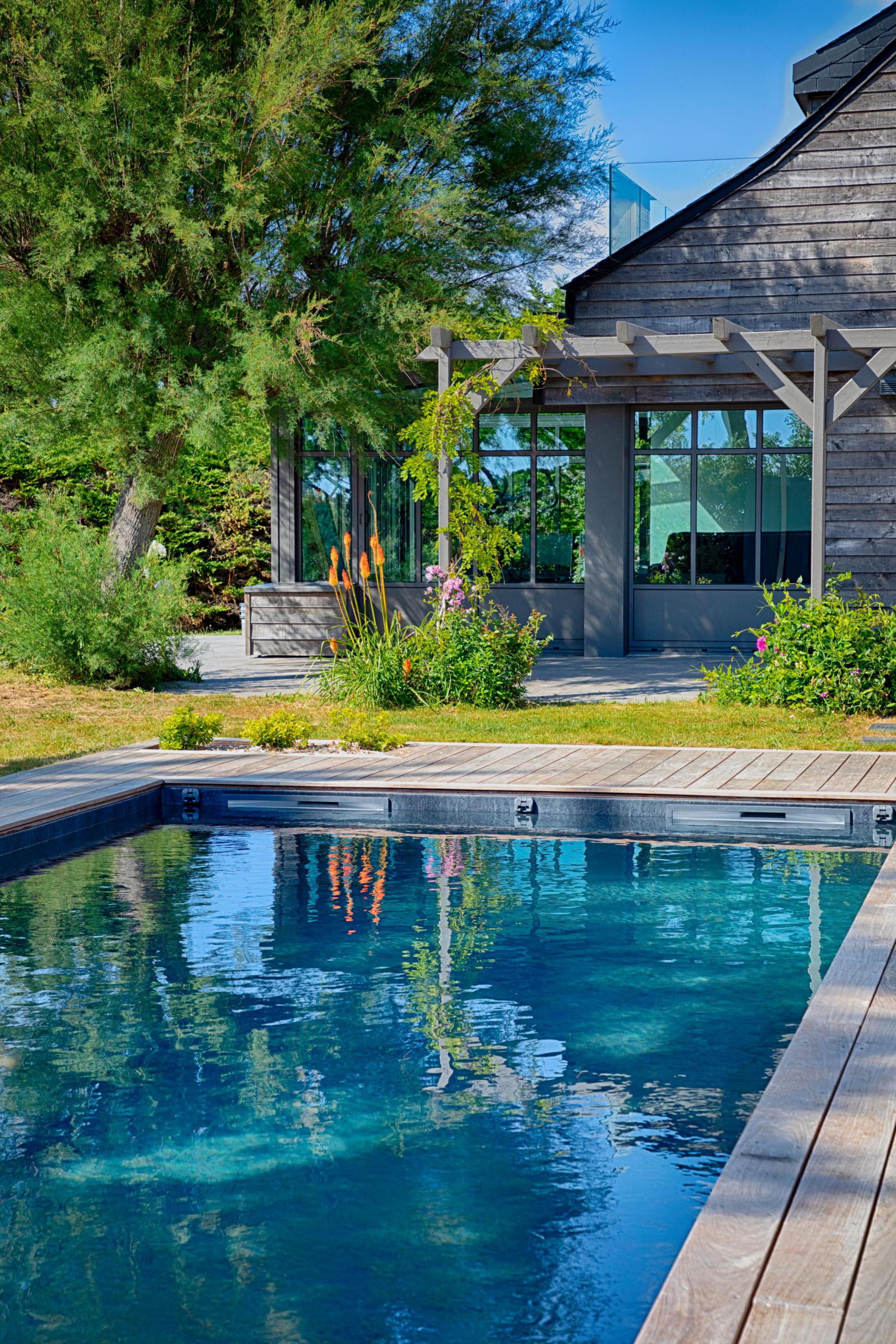 Piscine avec pergolas en fond